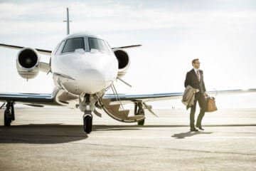 a business traveler stands next to the plane