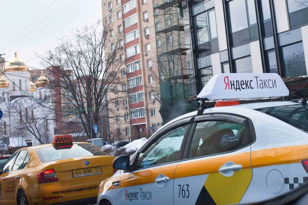 An airport transfer taxi cab on a city street.