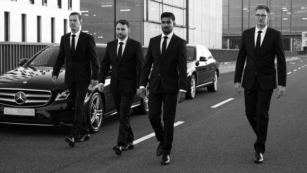 A group of men in suits walking down the street.
