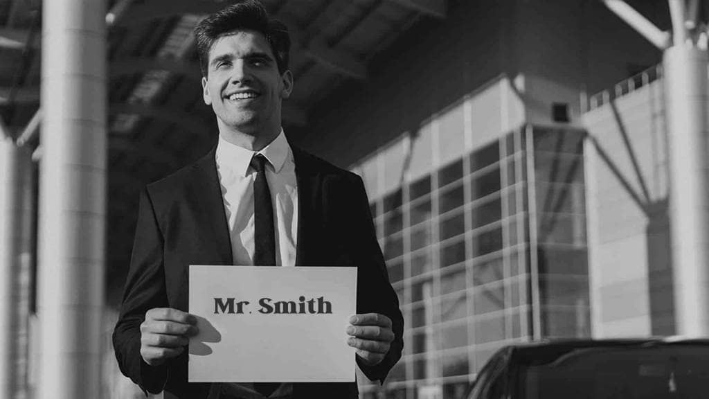 A man holding a sign that says mr smith.