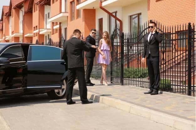 A group of people awaiting a limo from the best car service in Teterboro outside a house.